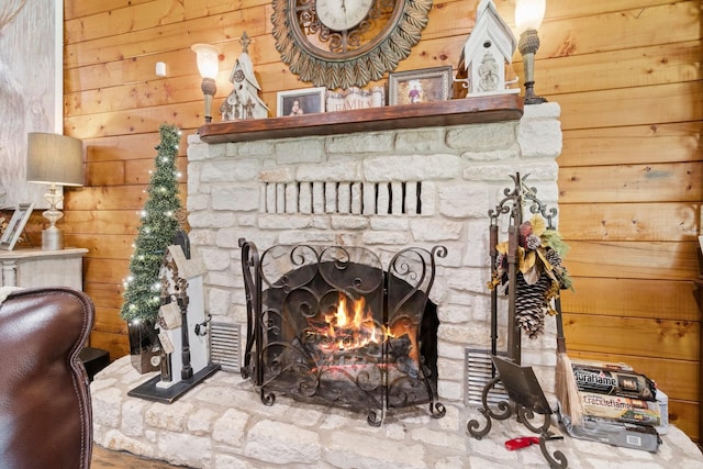details with a stone fireplace and wooden walls