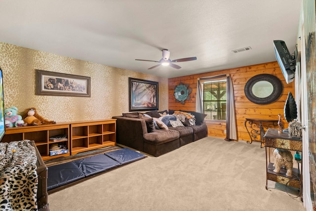 carpeted living room featuring a ceiling fan and visible vents