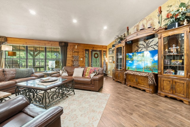 living room featuring wood walls, wood finished floors, and recessed lighting