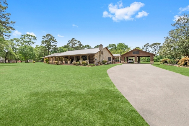 view of front of house featuring a chimney, a front lawn, driveway, a carport, and stone siding