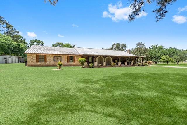 ranch-style house with a front yard, stone siding, a storage shed, and metal roof