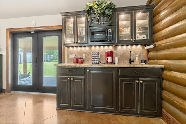 bar with rustic walls, wet bar, black microwave, and tile patterned flooring