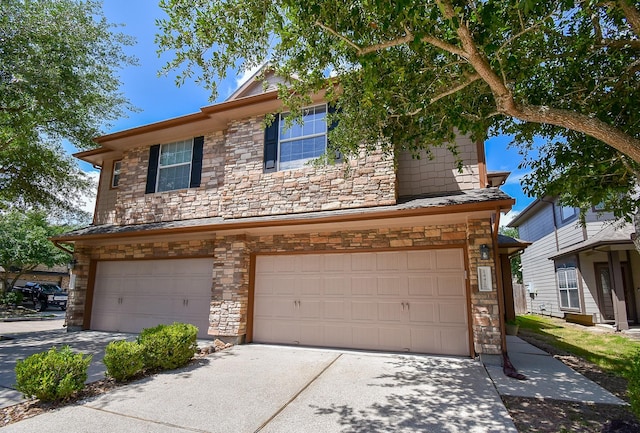 traditional-style home featuring an attached garage, concrete driveway, and stone siding