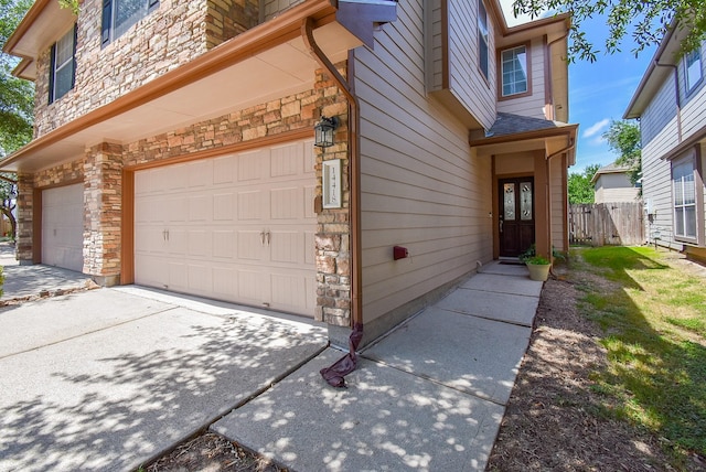 14418 Birch Knoll Ln, Houston, TX 77047 - view of exterior entry featuring stone siding and a garage
