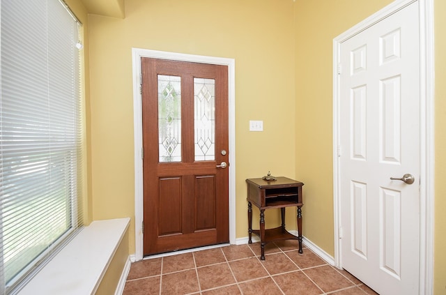 foyer entrance featuring dark tile patterned floors and baseboards