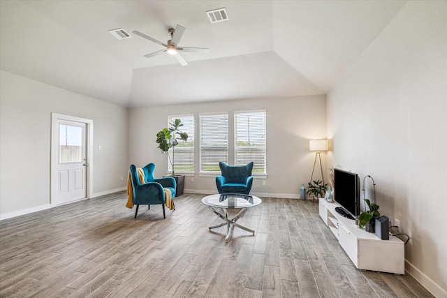sitting room with lofted ceiling, visible vents, light wood-type flooring, and a ceiling fan