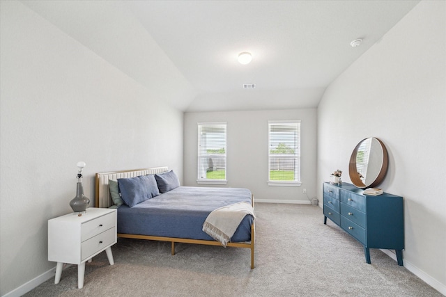 carpeted bedroom featuring lofted ceiling, visible vents, and baseboards