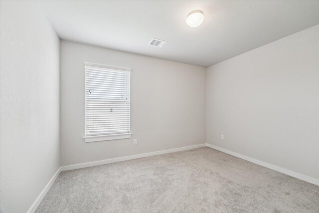 unfurnished room featuring visible vents, carpet flooring, and baseboards