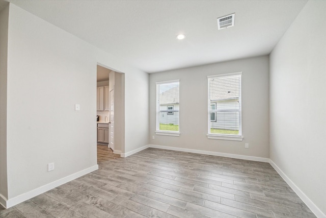 unfurnished room featuring visible vents, recessed lighting, light wood-style flooring, and baseboards