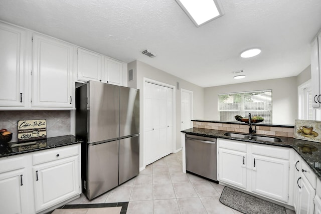 kitchen featuring visible vents, a sink, white cabinets, and stainless steel appliances
