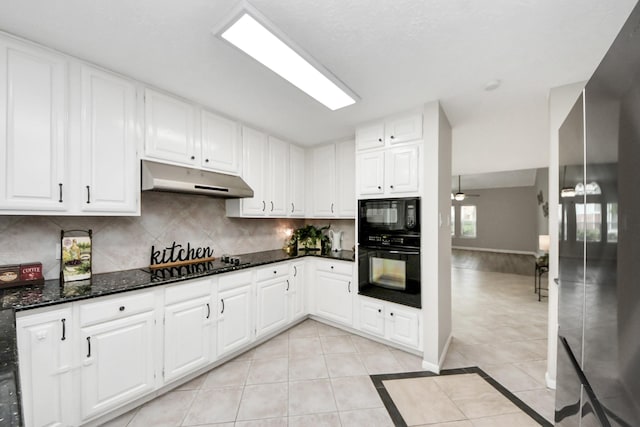 kitchen with decorative backsplash, under cabinet range hood, white cabinets, light tile patterned floors, and black appliances