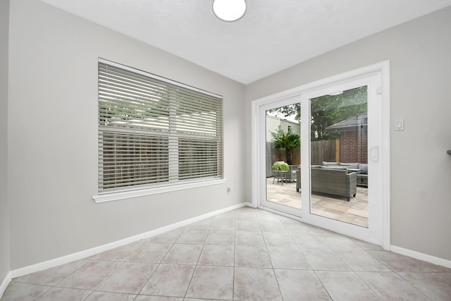 spare room with baseboards and light tile patterned floors