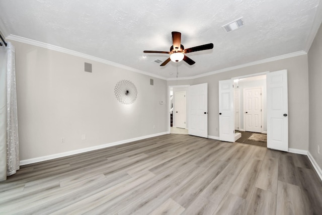 unfurnished bedroom featuring crown molding, baseboards, wood finished floors, and visible vents