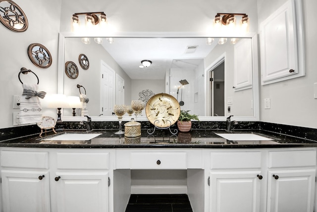 bathroom featuring double vanity, visible vents, and a sink