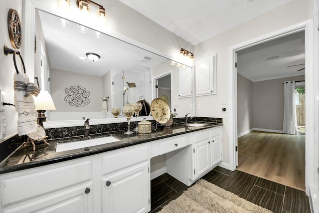 bathroom featuring double vanity, a sink, walk in shower, and wood tiled floor