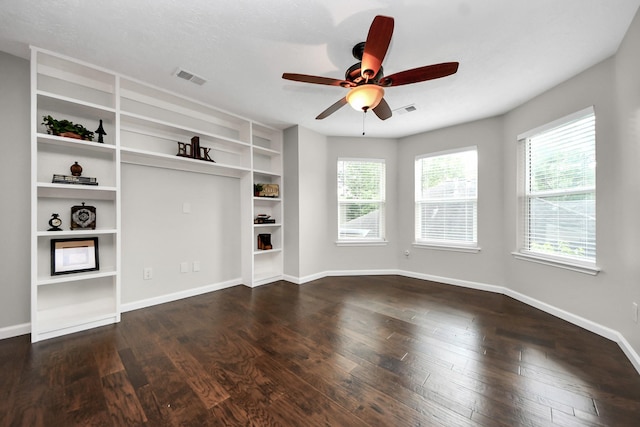 unfurnished living room with baseboards, a ceiling fan, dark wood-type flooring, and visible vents