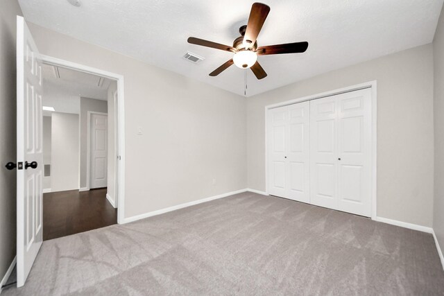 unfurnished bedroom featuring carpet floors, baseboards, visible vents, and attic access