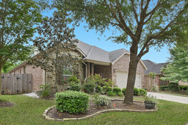 ranch-style home with an attached garage, a front lawn, fence, and brick siding