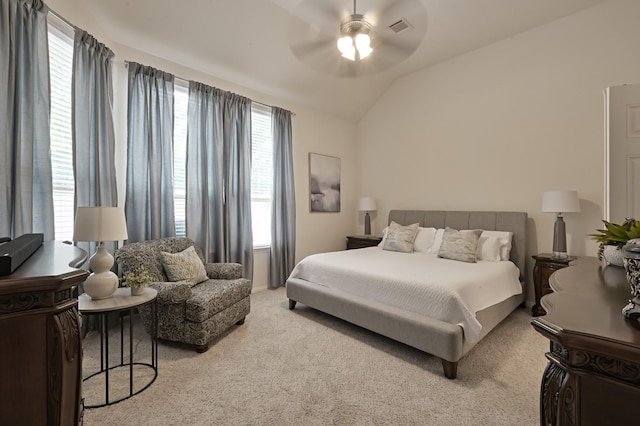 bedroom with visible vents, a ceiling fan, light carpet, and vaulted ceiling