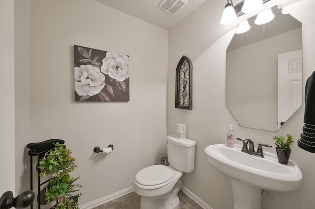 bathroom with a sink, tile patterned floors, toilet, visible vents, and baseboards