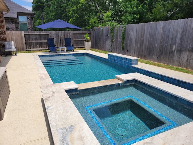 view of swimming pool featuring a fenced backyard and a pool with connected hot tub