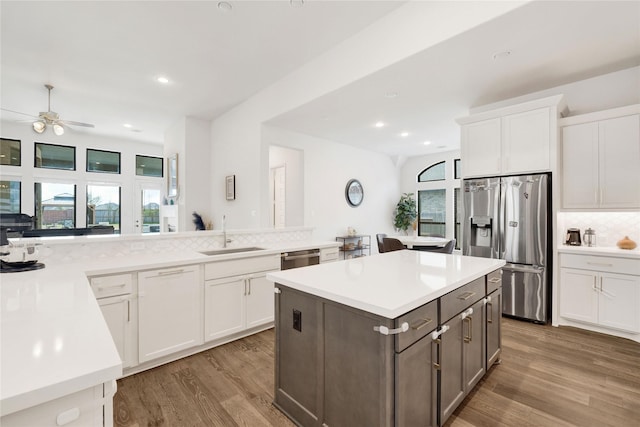 kitchen featuring light countertops, light wood finished floors, stainless steel appliances, and a sink