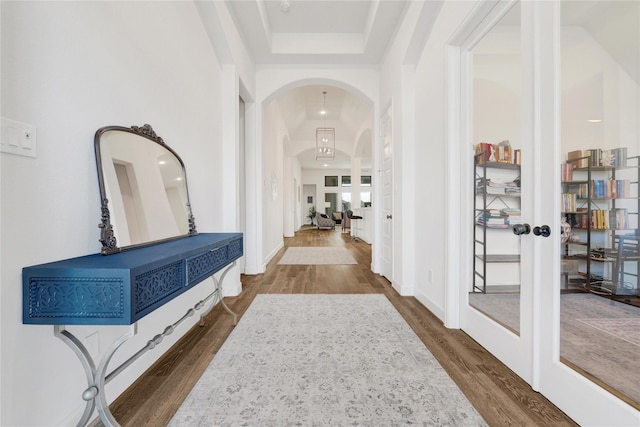 interior space featuring french doors, arched walkways, and dark wood-style flooring