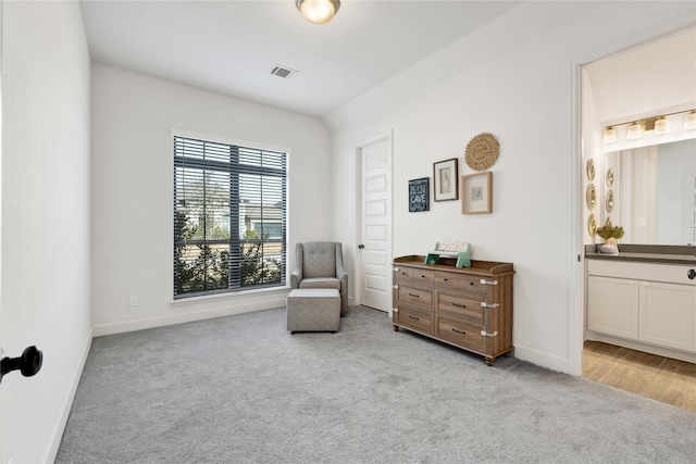 living area with baseboards, visible vents, and carpet