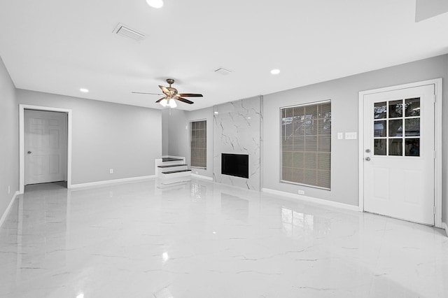 unfurnished living room with visible vents, baseboards, recessed lighting, marble finish floor, and a fireplace