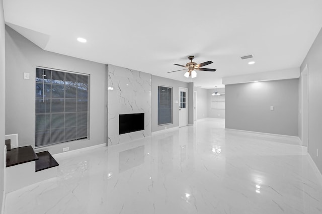 unfurnished living room with a ceiling fan, marble finish floor, baseboards, visible vents, and recessed lighting
