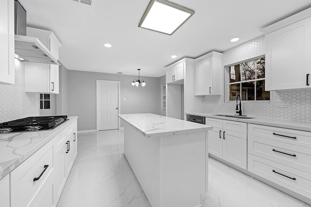 kitchen featuring stainless steel gas stovetop, recessed lighting, wall chimney range hood, a sink, and a kitchen island
