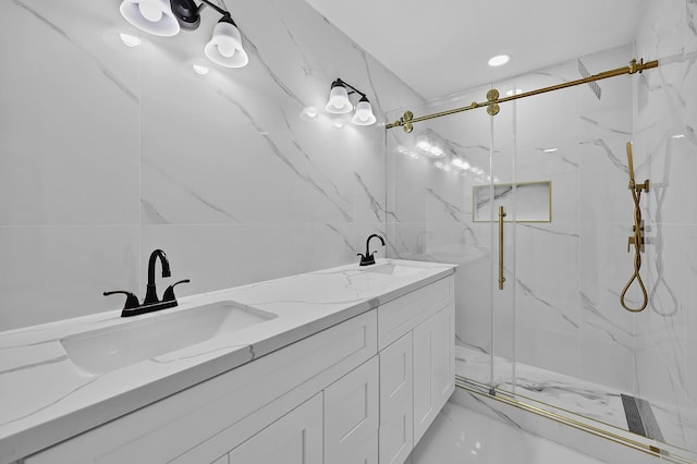 full bath featuring a marble finish shower, a sink, marble finish floor, and double vanity