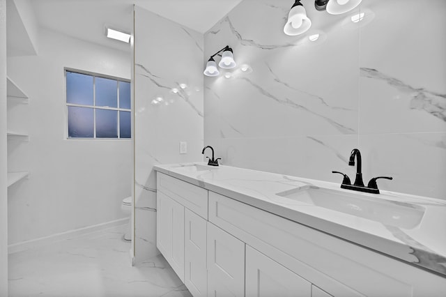 full bathroom with marble finish floor, a sink, double vanity, and toilet