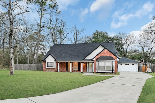 view of front facade with fence, brick siding, a front yard, and concrete driveway