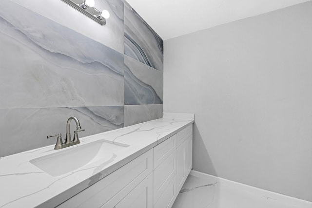bathroom featuring baseboards, marble finish floor, and vanity