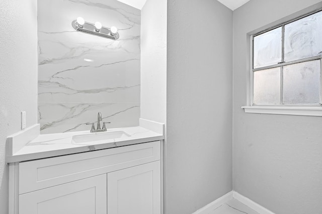full bath featuring baseboards, marble finish floor, and vanity