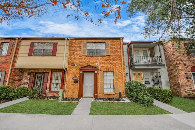 7954 Grove Ridge Dr, Houston, TX 77061 - view of property with a front yard, a balcony, and brick siding
