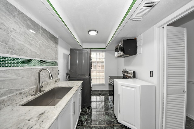 7954 Grove Ridge Dr, Houston, TX 77061 - washroom featuring marble finish floor, baseboards, a sink, and visible vents