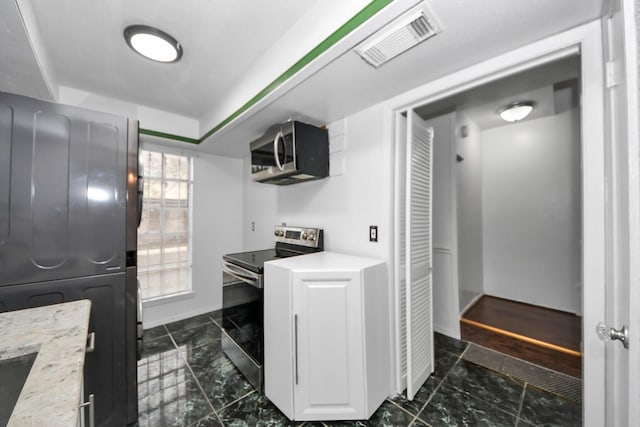 7954 Grove Ridge Dr, Houston, TX 77061 - kitchen featuring white cabinets, marble finish floor, stainless steel appliances, and visible vents