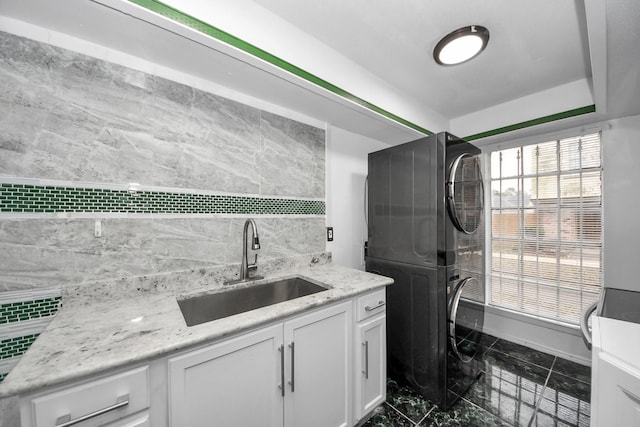 7954 Grove Ridge Dr, Houston, TX 77061 - laundry area with marble finish floor, cabinet space, stacked washer / dryer, and a sink