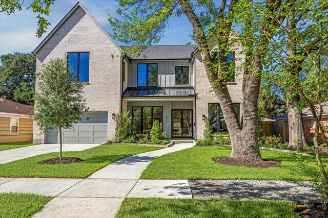 4016 Branard St, Houston, TX 77027 - view of front facade with concrete driveway, brick siding, a standing seam roof, a front yard, and a garage