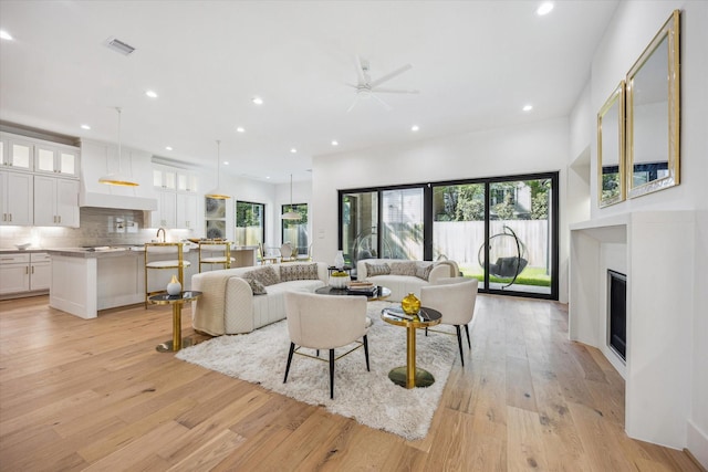4016 Branard St, Houston, TX 77027 - living room with visible vents, recessed lighting, light wood-style floors, a ceiling fan, and a fireplace