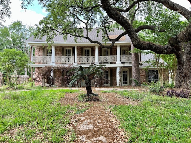 view of front of home featuring a balcony and fence