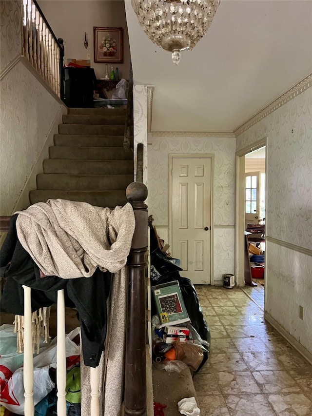 foyer featuring wallpapered walls, baseboards, stairs, and crown molding