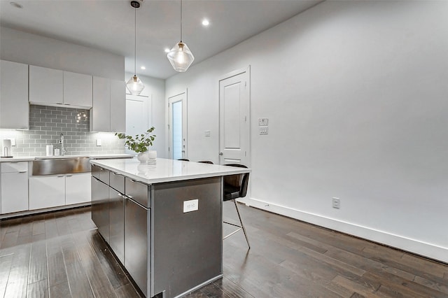 5841 Dolores St, Houston, TX 77057 - kitchen featuring a sink, dark wood-style flooring, recessed lighting, a breakfast bar area, and a kitchen island