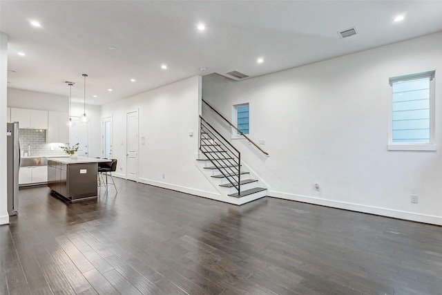 5841 Dolores St, Houston, TX 77057 - unfurnished living room with dark wood-style floors, stairway, recessed lighting, baseboards, and a sink