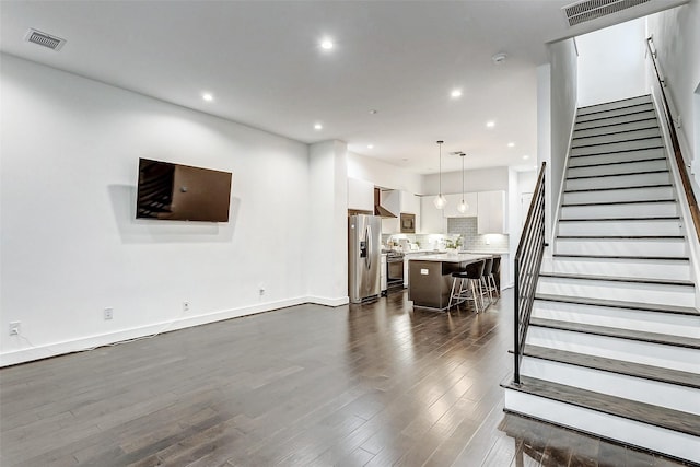 5841 Dolores St, Houston, TX 77057 - living area featuring dark wood finished floors, recessed lighting, stairs, and baseboards
