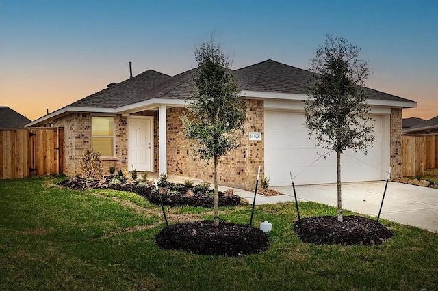 ranch-style house featuring fence, an attached garage, driveway, and brick siding