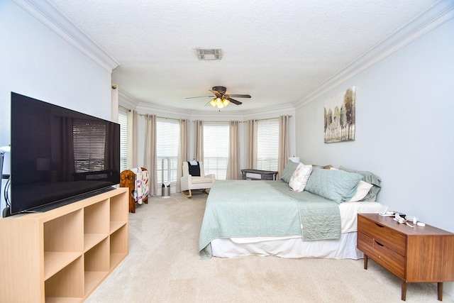 bedroom with a ceiling fan, a textured ceiling, visible vents, carpet floors, and ornamental molding