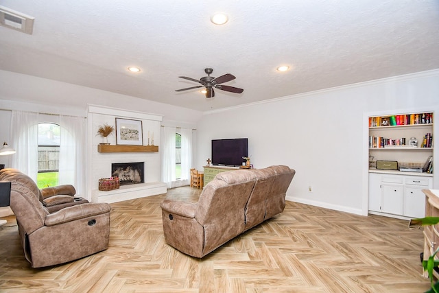 living room with baseboards, ceiling fan, a textured ceiling, and visible vents